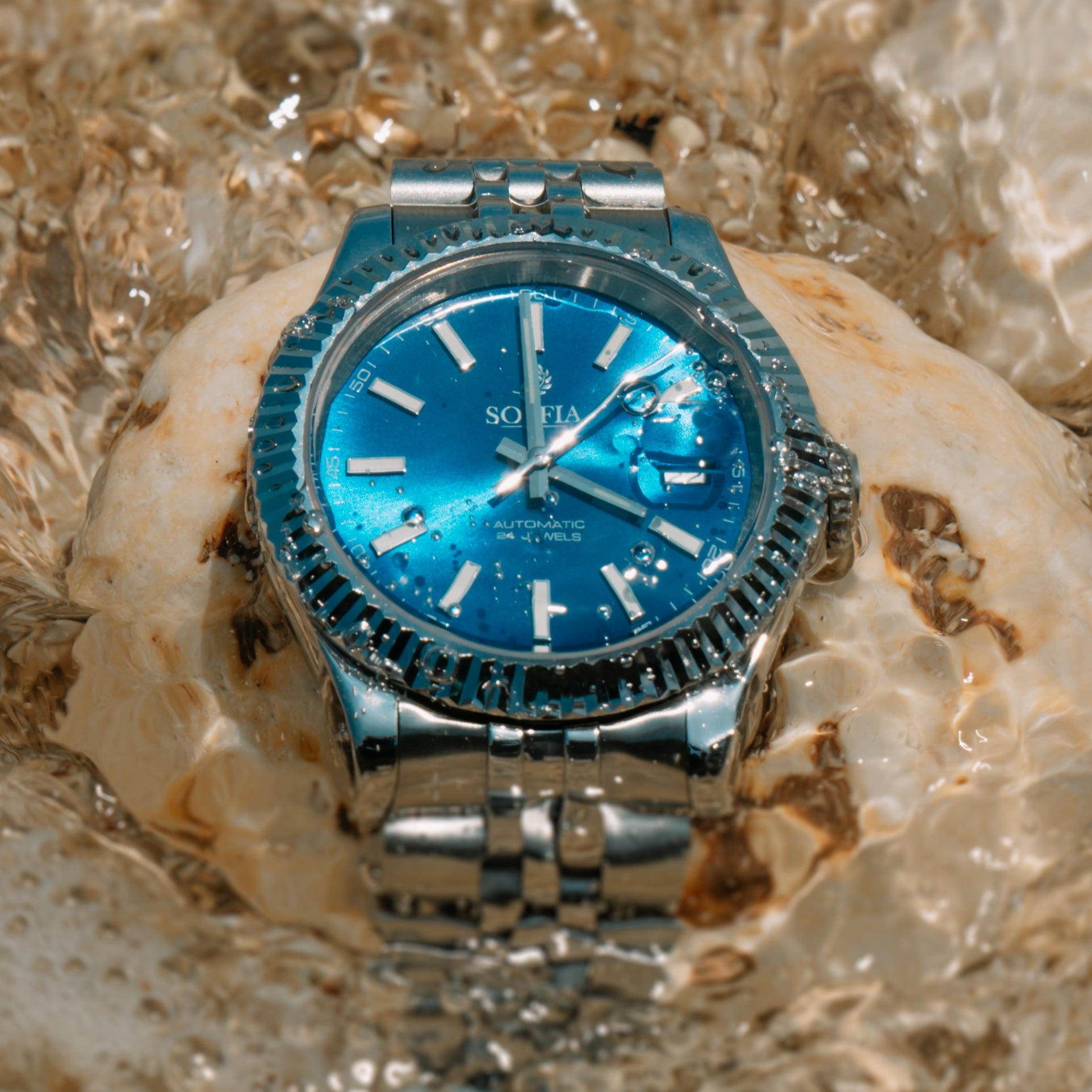 Silver watch with a blue face on a textured stone surface
