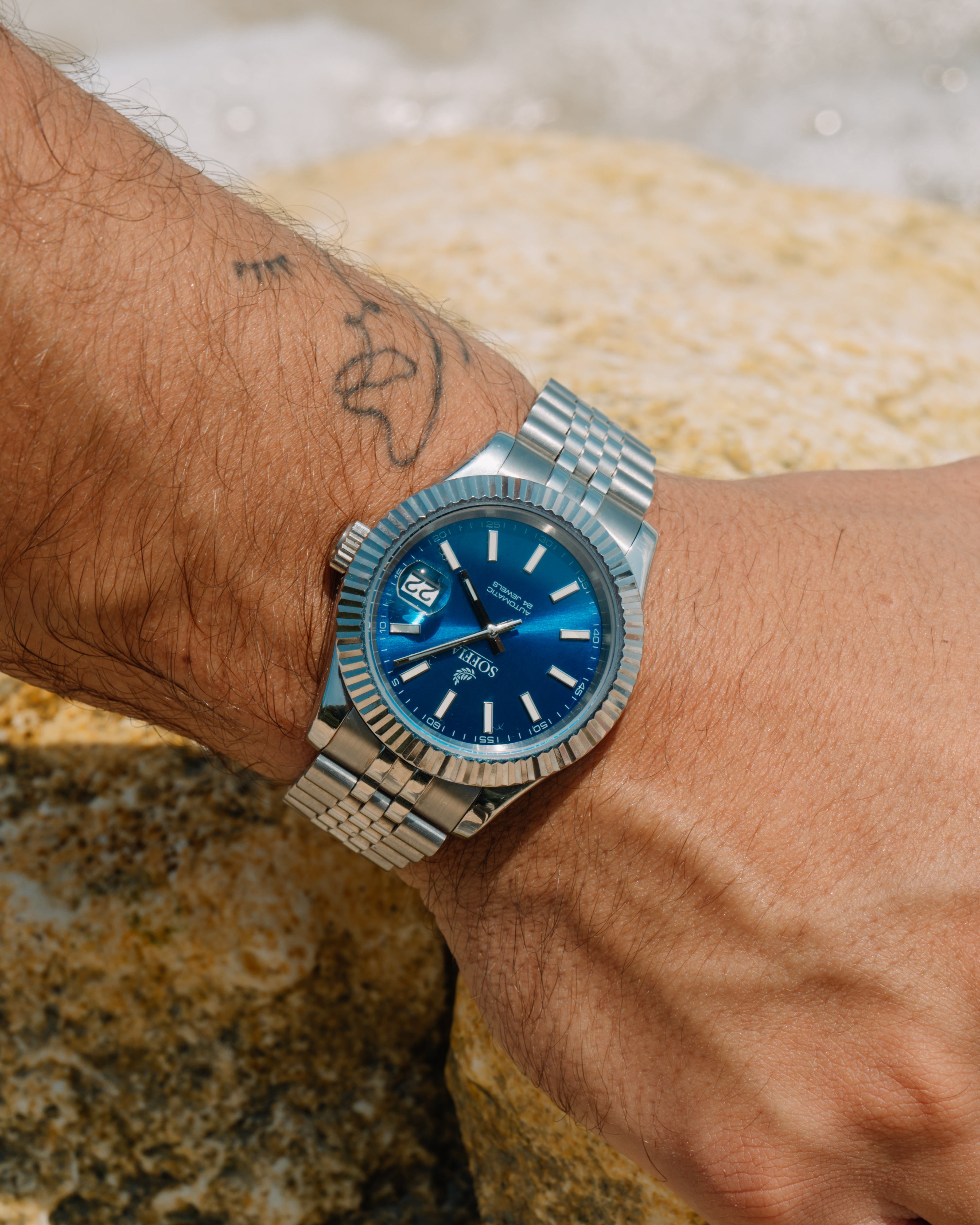 Beautiful watch with blue dial and silver bracelet on a men wrist